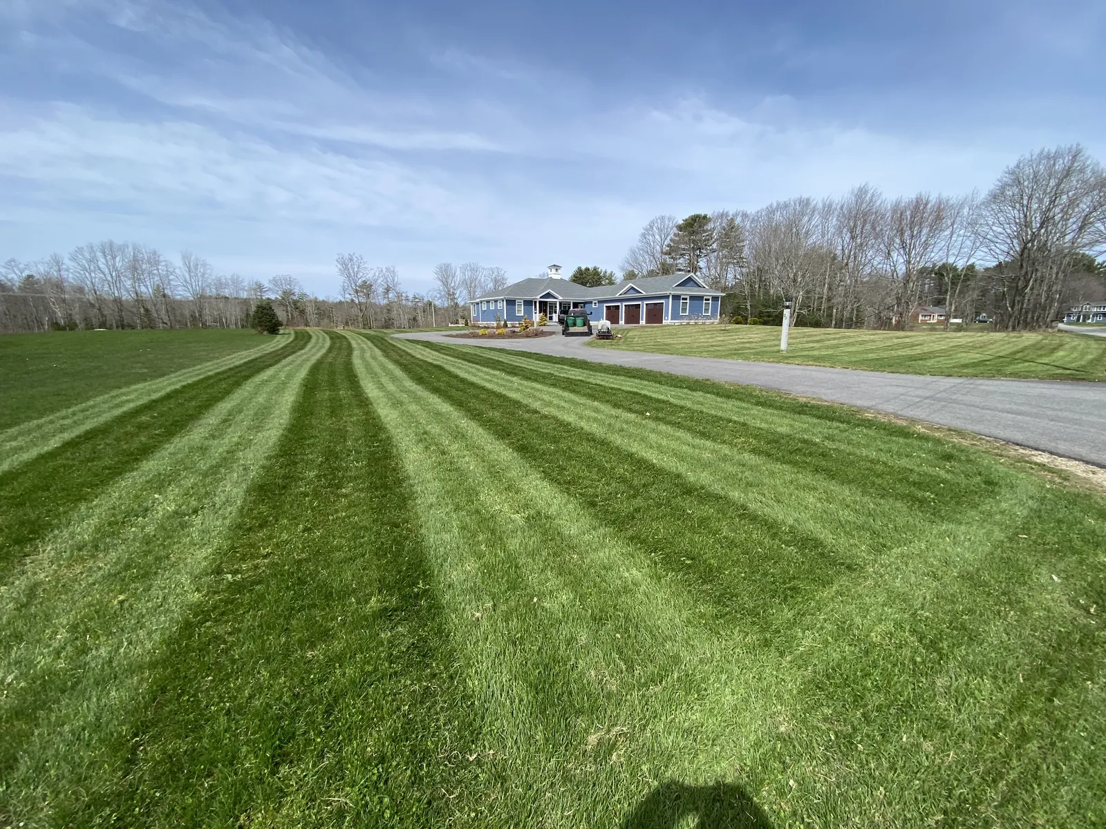 Freshly mowed lawn with wide stripes beside a home