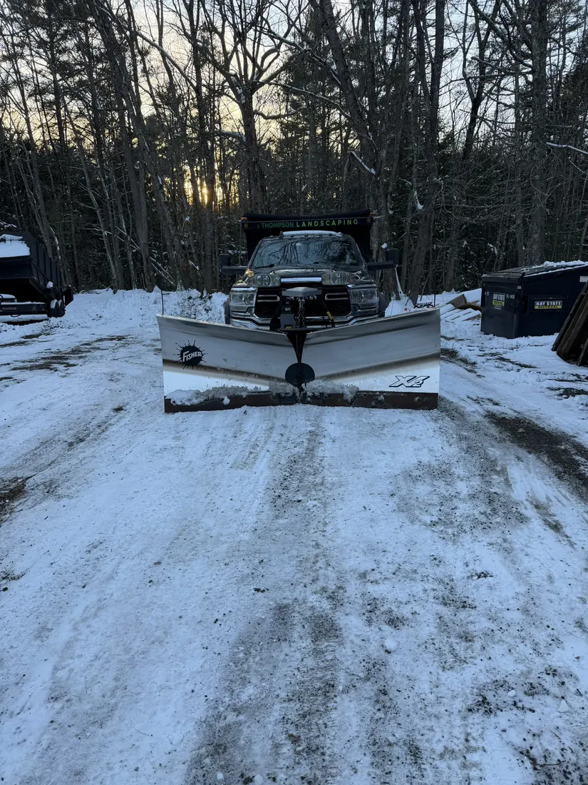 Plow truck on a snow-covered residential driveway
